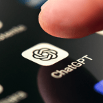 ChatGPT app icon on smartphone screen with pushing finger. Artificial intelligence chatbot service on mobile phone