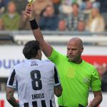 Dutch referee Rob Dieperink handing a yellow card to Heracles midfielder Mario Engels, October 19, 2025.
