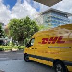 A yellow DHL van parked on a sidewalk at the Hong Kong Science Park. 2021