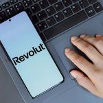 A hand, Revolut app on a phone.