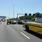 Several people use an umbrella to create shade on a scorching hot day after a collision on the A4, June 24, 2026.