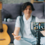 Kidfluencer - teenage boy using smartphone to record video for internet vlog