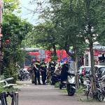 Police talk to residents as firefighters respond to an explosion and fire on Ombilinstraat in Amsterdam. 20 June 2026