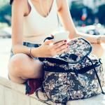 Middle section of a young woman scrolling on a smartphone