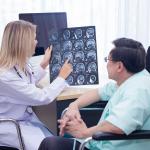 A neurologist talks about the brain scans with her patient.