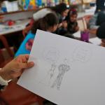 A_girl_holds_up_a_drawing_of_a_bride_and_groom_during_a_discussion_about_child_marriage_with_teenage_Syrian_refugee_girls_in_a_community_centre_in_southern_Lebanon_(14680478784)