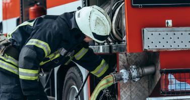 A firefighter prepares a hose.