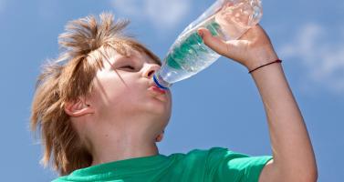 Boy drinking water in the summer heat
