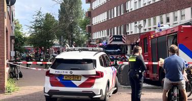 Police talk to residents as firefighters respond to an explosion and fire on Ombilinstraat in Amsterdam. 20 June 2026