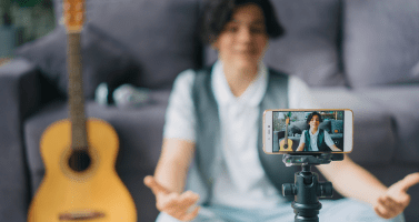 Kidfluencer - teenage boy using smartphone to record video for internet vlog