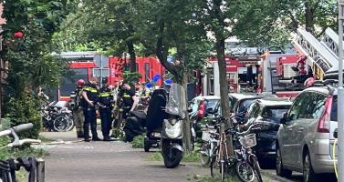 Police talk to residents as firefighters respond to an explosion and fire on Ombilinstraat in Amsterdam. 20 June 2026