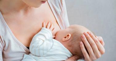 A mother breast feeds her baby.
