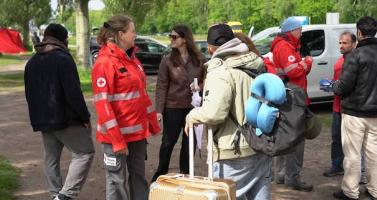 An undated image of a Red Cross worker talking to people at the Ter Apel registration center.
